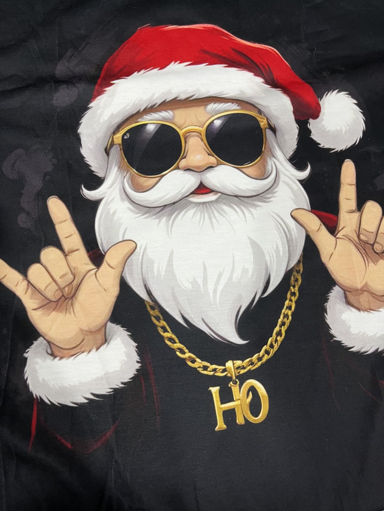 Cartoon Santa Claus wearing sunglasses, gold chain, and 'HO' necklace on a dark background