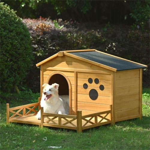 Wooden dog house with a white dog inside, surrounded by greenery.