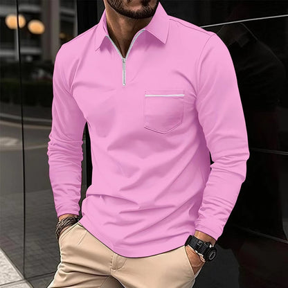 Man wearing a pink long-sleeve shirt with a zipper and pocket, standing against a reflective surface.