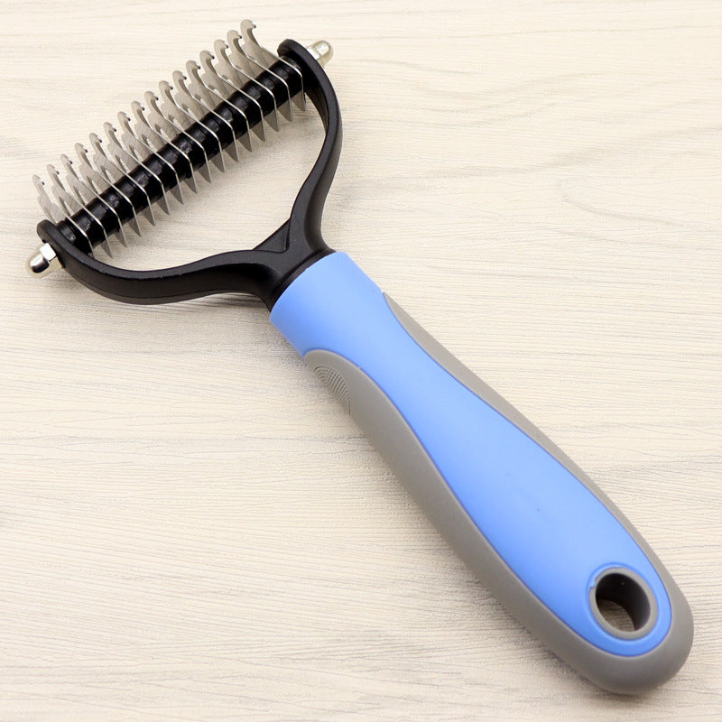 Pet grooming brush with blue handle on a light wooden surface