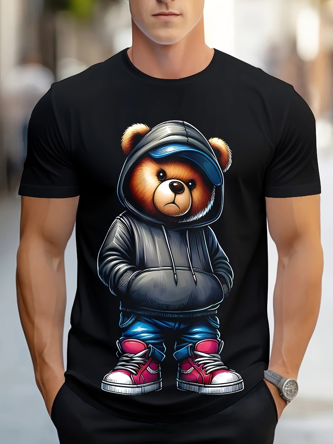 Black t-shirt with a bear graphic wearing a hoodie and blue pants, worn by a person.