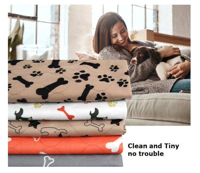 Stack of pet blankets with paw and bone patterns next to a woman holding a dog.