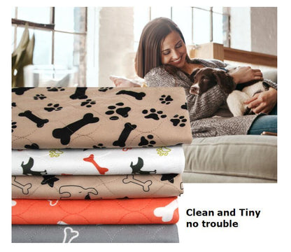 Stack of pet blankets with paw and bone patterns next to a woman holding a dog.