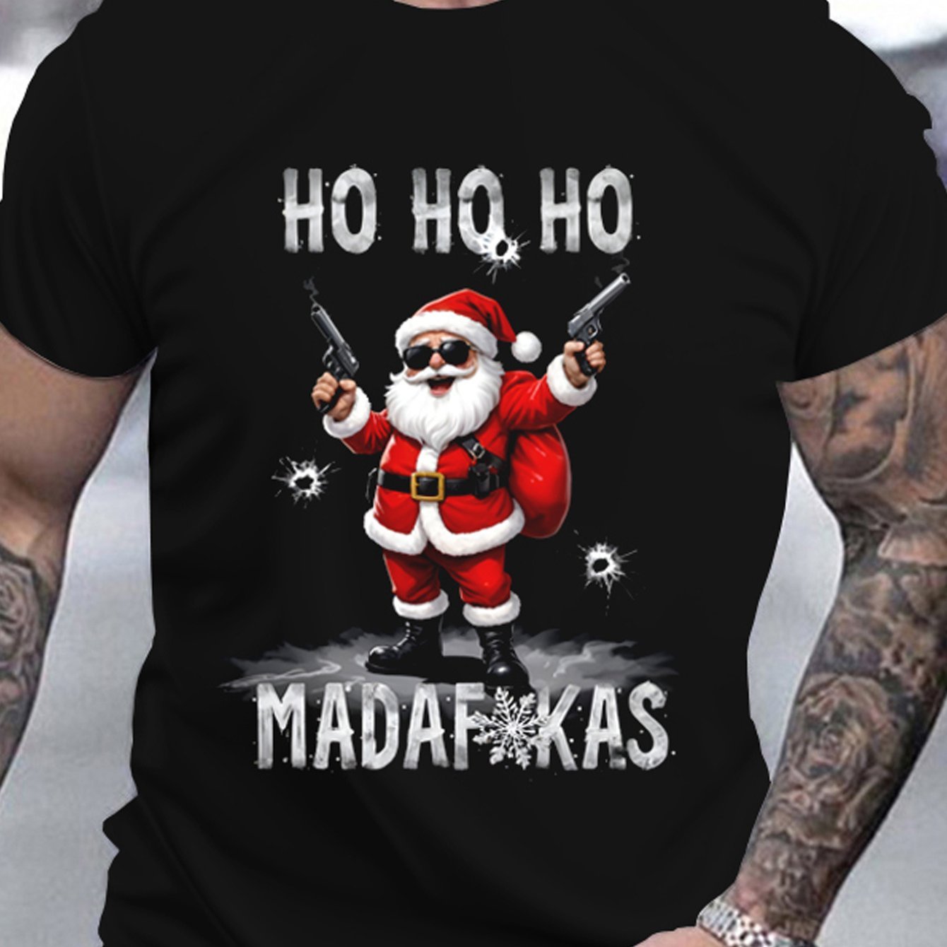 Black t-shirt with a graphic of Santa Claus holding guns and text 'HO HO HO MADAFUKAS' on a plain background.