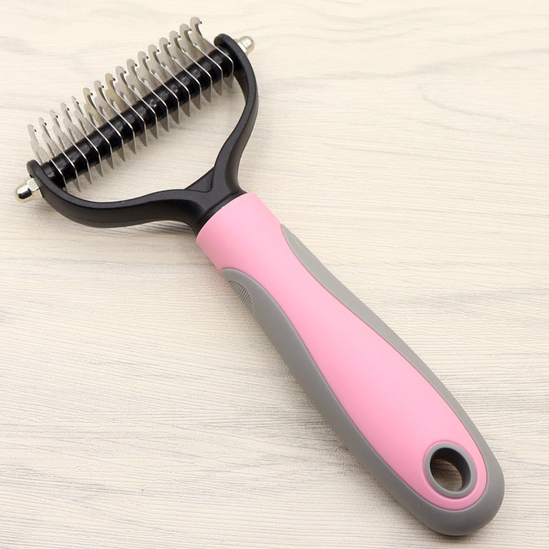 Pet grooming brush with pink handle on a light wooden surface