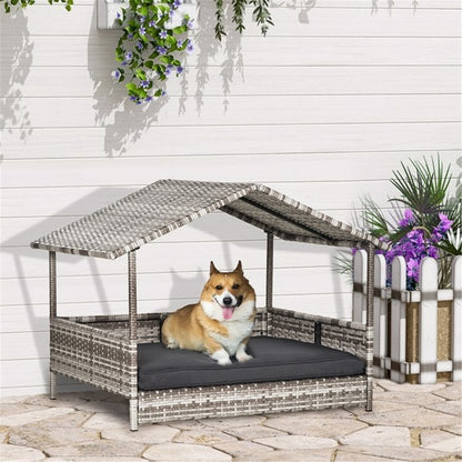Dog sitting in a wicker pet house with a canopy on a stone patio.