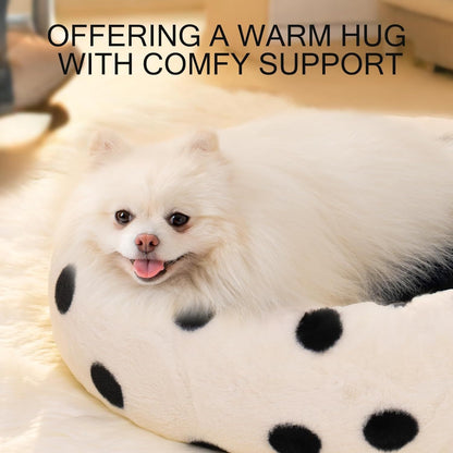 Small white dog lying on a polka dot pet bed with text 'Offering a warm hug with comfy support'.
