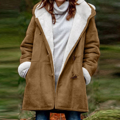 Person wearing a brown coat with white fur lining in a natural setting