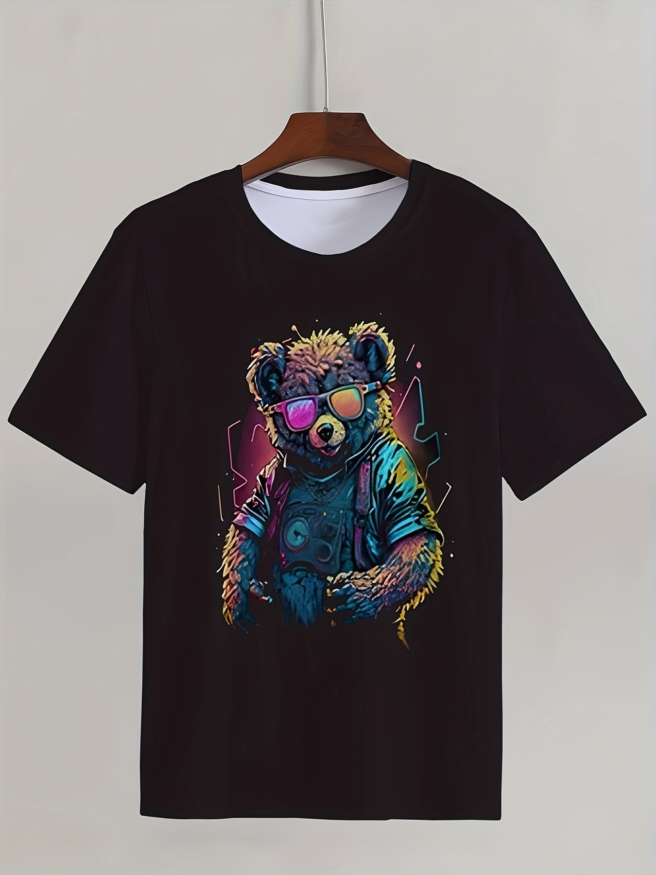 Black t-shirt with a colorful bear graphic on a hanger against a white background