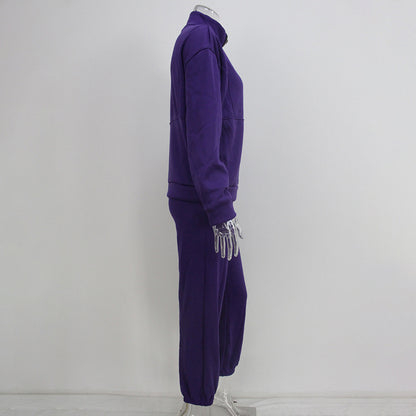 Purple tracksuit with matching gloves on a mannequin against a white background