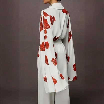 Person wearing a white outfit with red floral patterns on a dark background