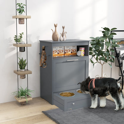Gray pet feeding station with a dog eating from one of the drawers, plants, and decor in the background.