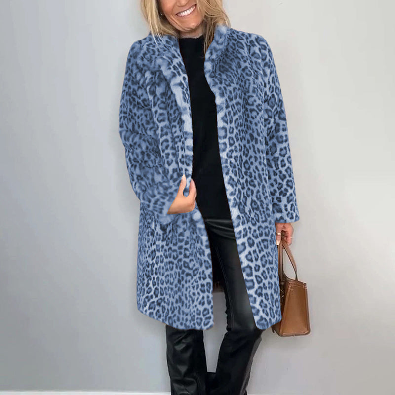 Person wearing a blue leopard print coat against a plain background