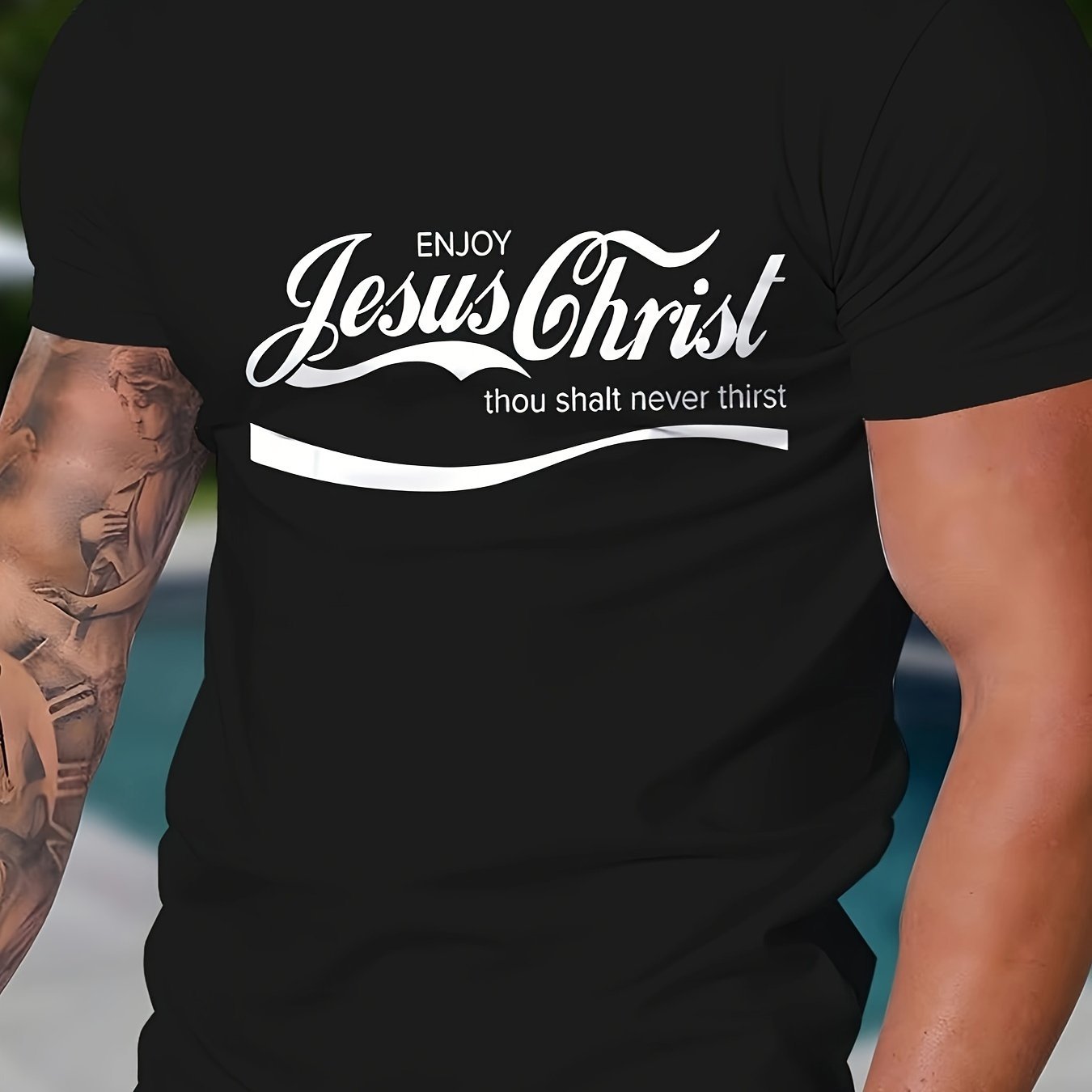 Black t-shirt with 'Enjoy Jesus Christ thou shalt never thirst' text worn by a person with tattoos.