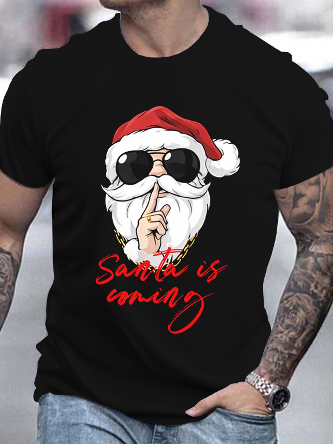 Black t-shirt with a graphic of Santa Claus wearing sunglasses and the text 'Santa is coming' worn by a person.