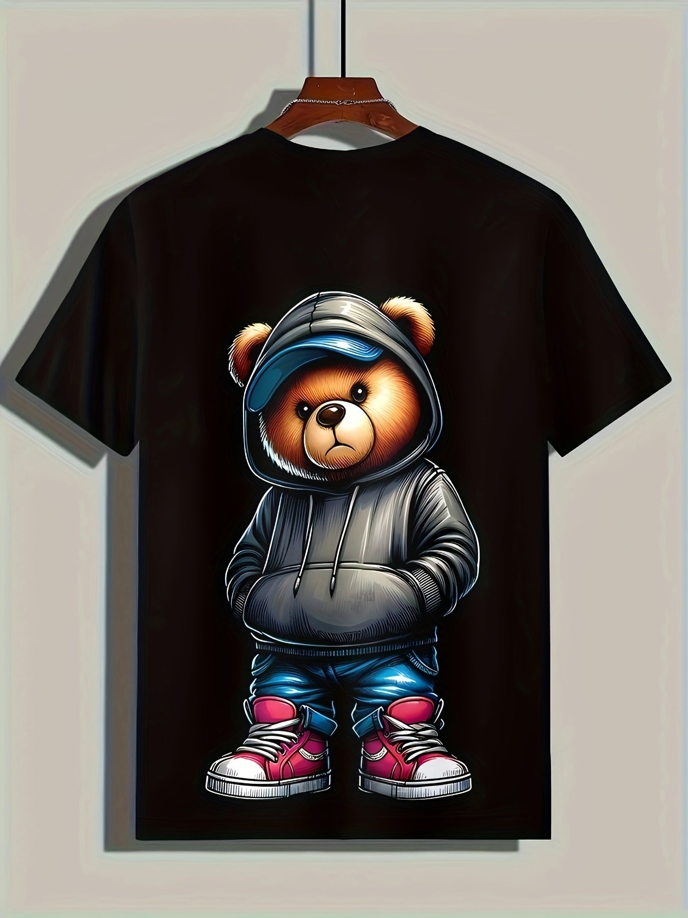 Black t-shirt with a bear graphic in a hoodie on a beige background
