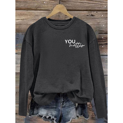 Dark gray sweatshirt with 'YOU matter' text on a wooden background