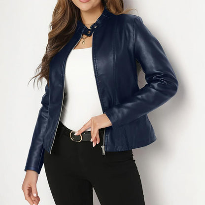 Person wearing a blue leather jacket over a white top on a light background
