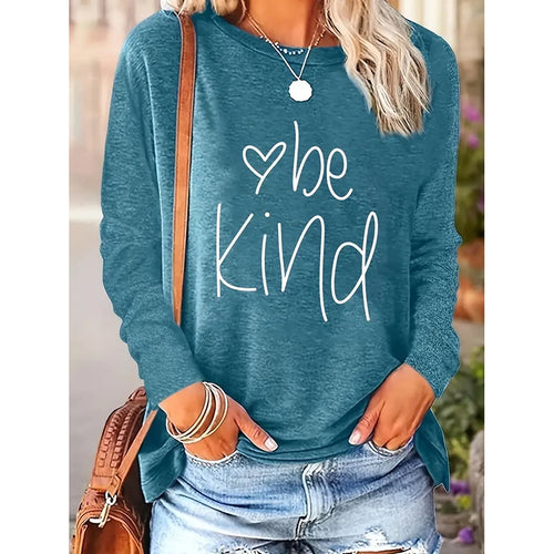 Blue sweatshirt with 'be Kind' text worn by a person outdoors.
