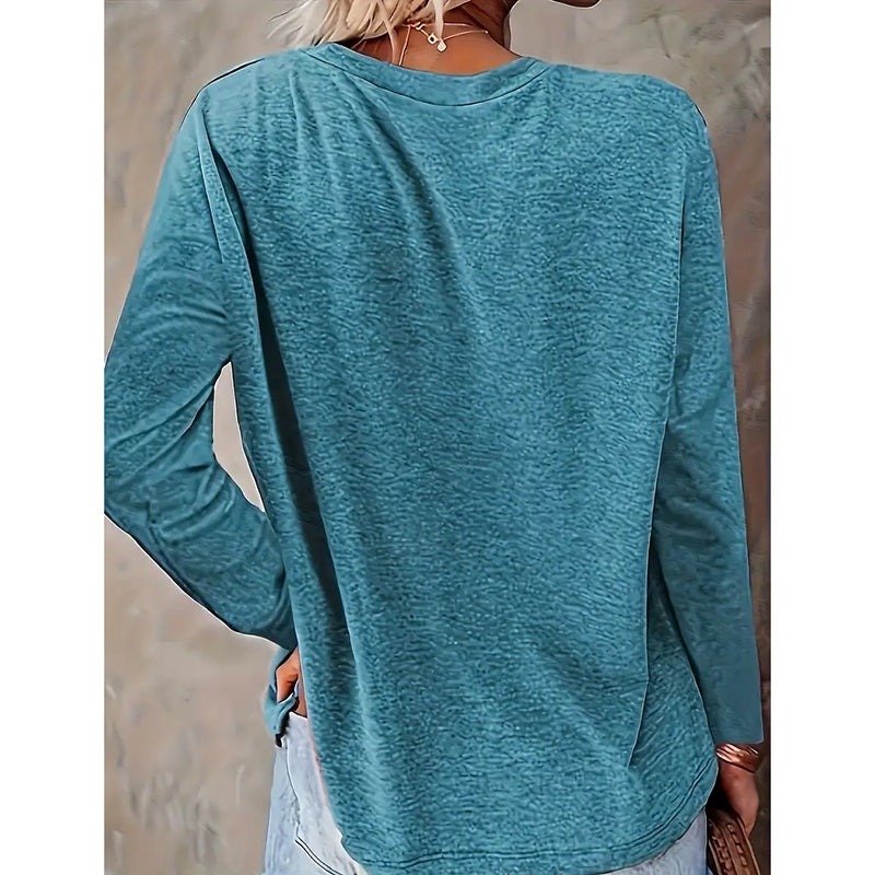 Teal long-sleeve top worn by a person with a neutral background