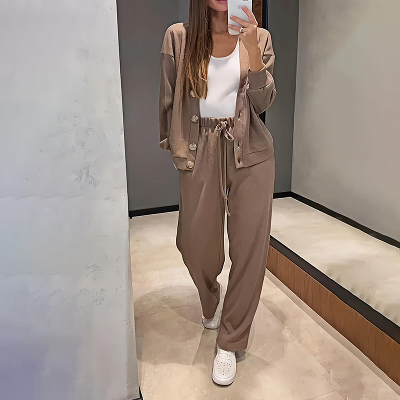 Person wearing a brown outfit taking a mirror selfie in a store.