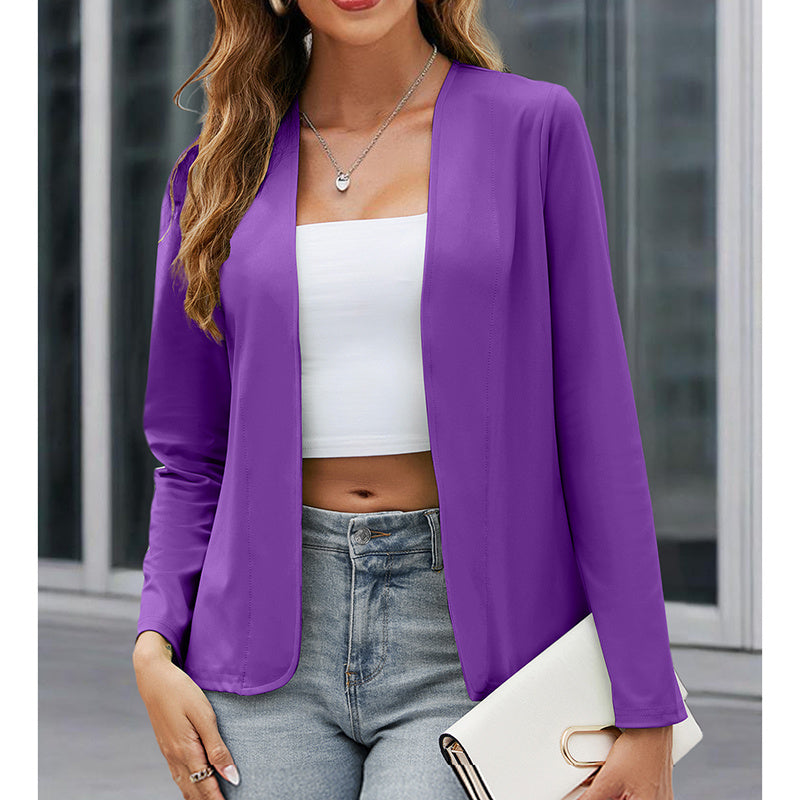 Woman wearing a purple blazer over a white top and jeans, holding a clutch.