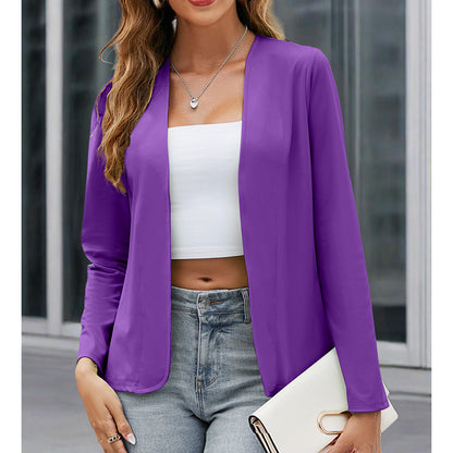 Woman wearing a purple blazer over a white top and jeans, holding a clutch.