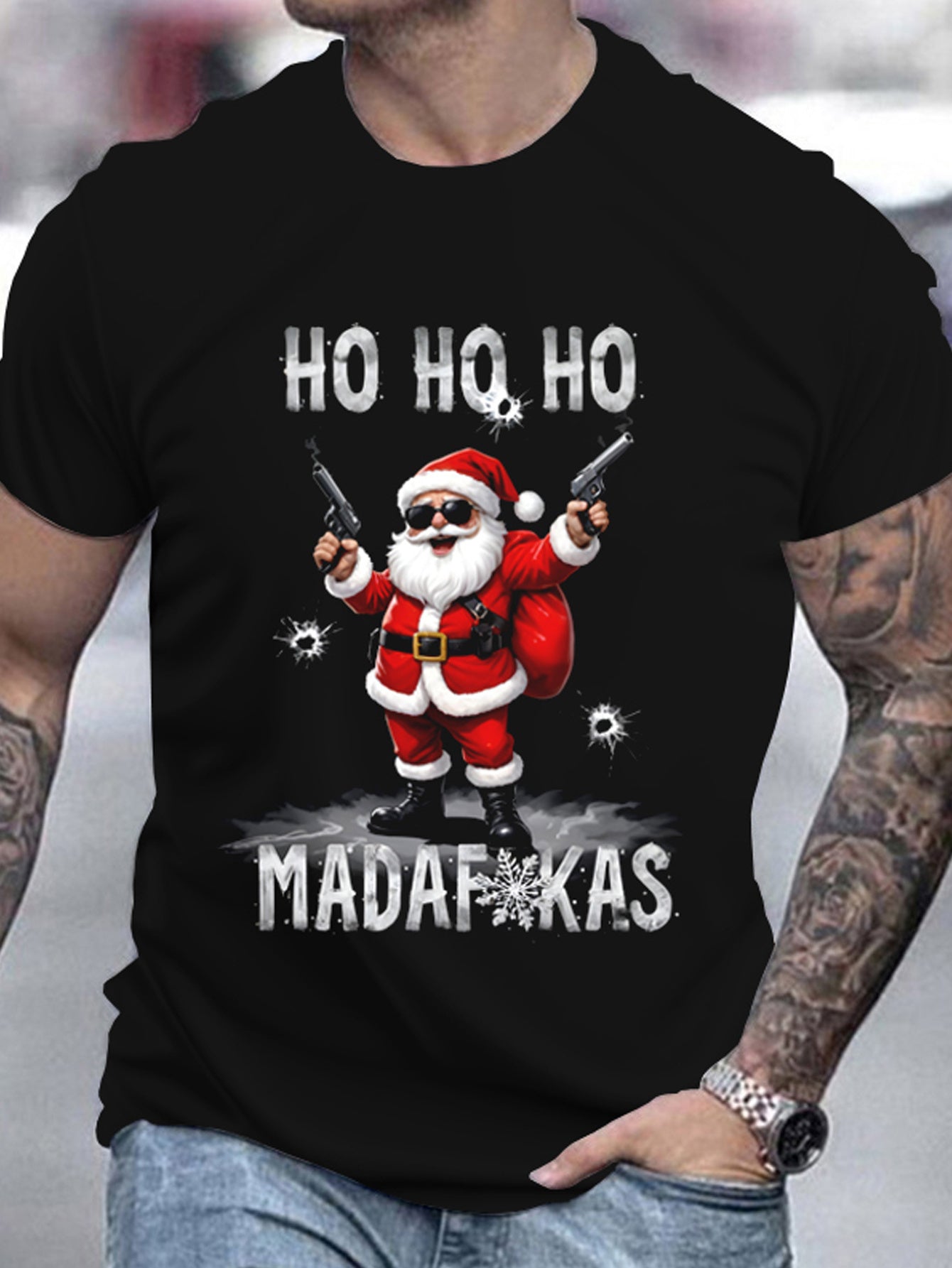 Black t-shirt with a graphic of Santa Claus holding guns and text 'HO HO HO MADAFAKAS' worn by a person.
