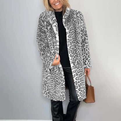 Person wearing a leopard print coat against a plain background