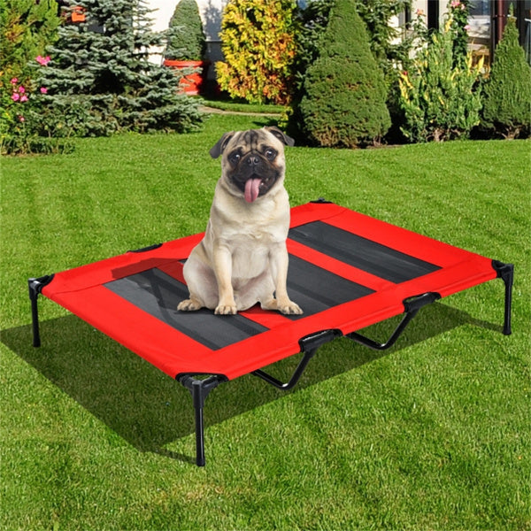 Dog sitting on a red and black pet cot in a garden