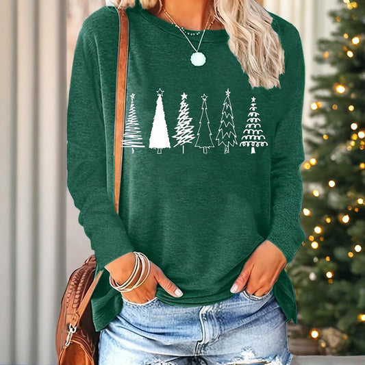 Person wearing a green sweater with Christmas tree designs in front of a decorated Christmas tree.