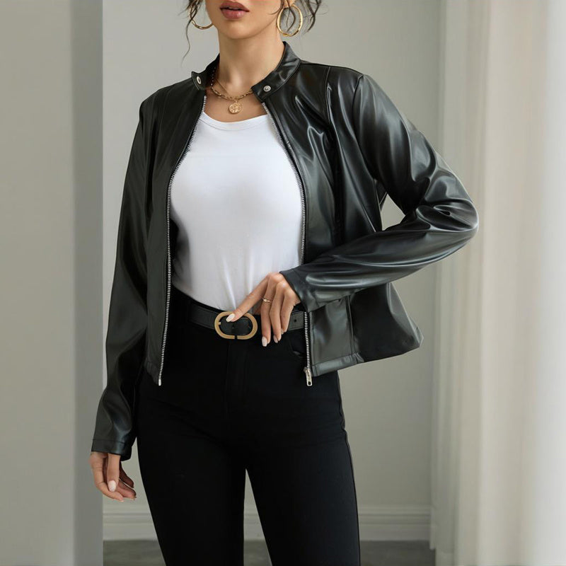 Person wearing a black leather jacket over a white top and black pants.