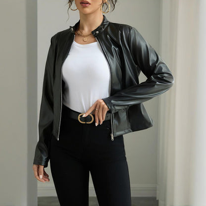Person wearing a black leather jacket over a white top and black pants.