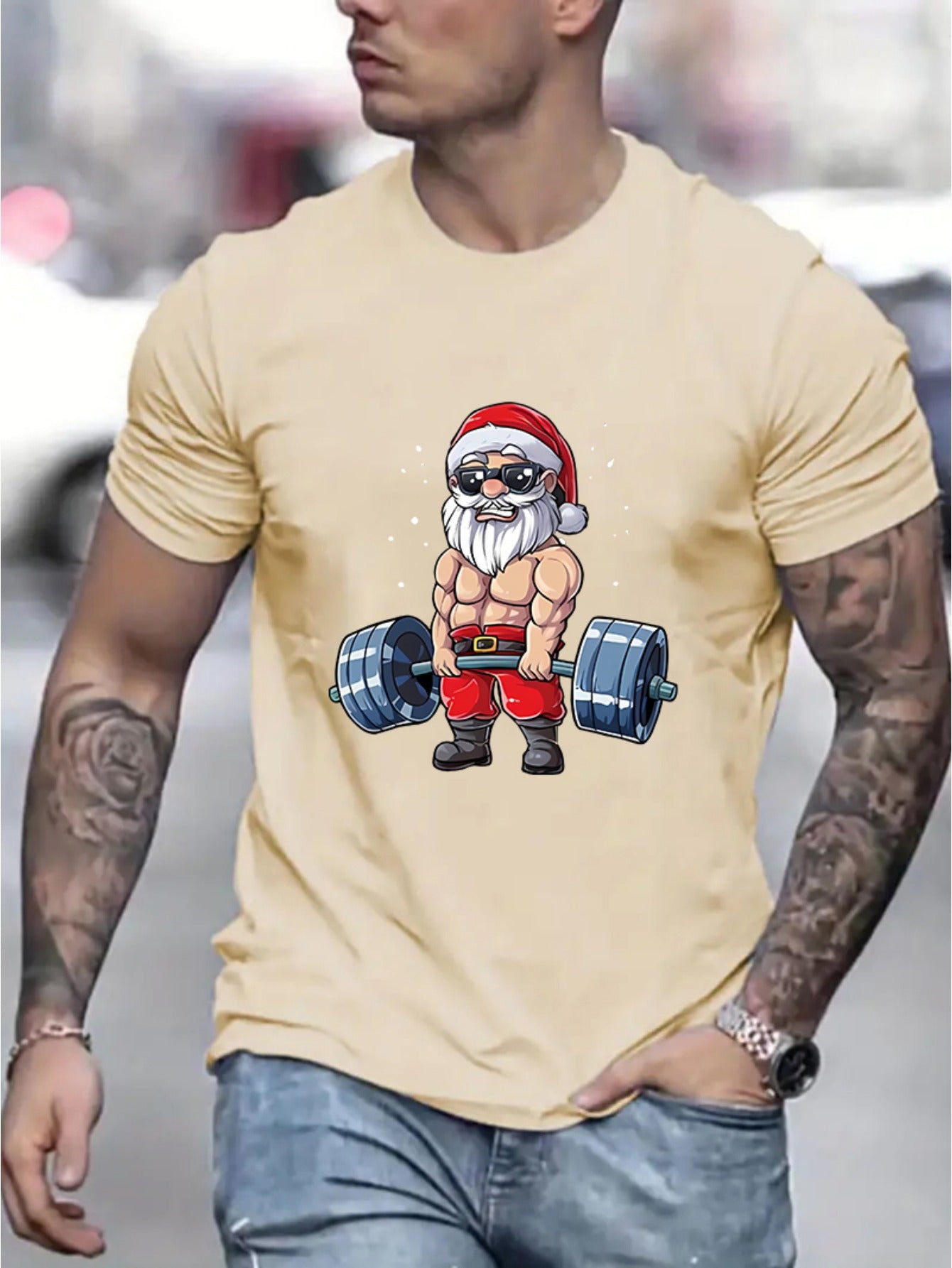Man wearing a beige t-shirt with a graphic of Santa Claus lifting weights.