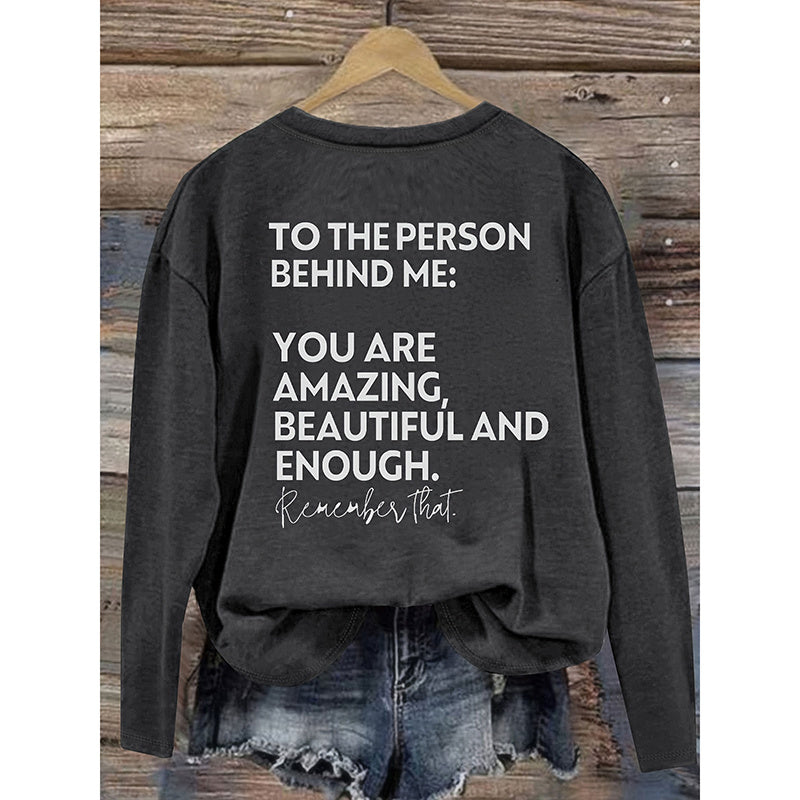 Black sweatshirt with motivational quote on a wooden background