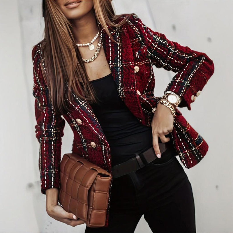 Woman wearing a red plaid blazer with a brown clutch against a neutral background