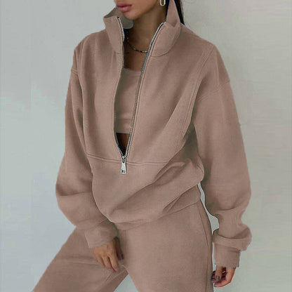 Person wearing a beige tracksuit with a high zipper on a plain background