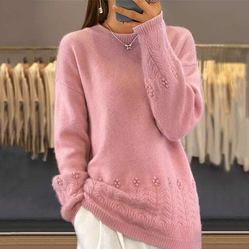 Person wearing a pink sweater with floral patterns in a clothing store.