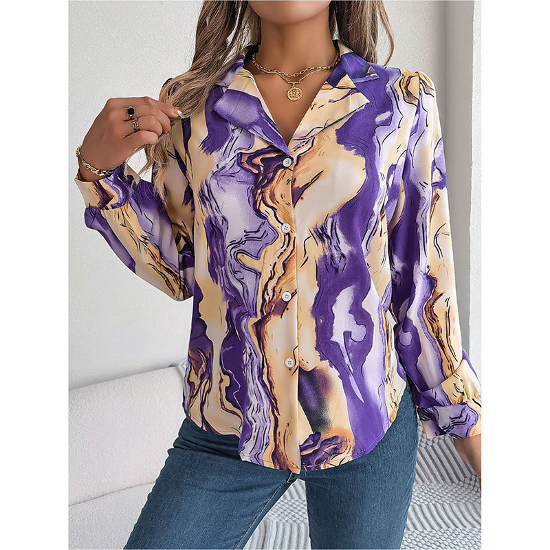 Woman wearing a long-sleeve shirt with a purple and gold abstract pattern.
