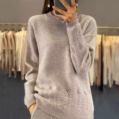 Person wearing a gray sweater with floral patterns in a clothing store.