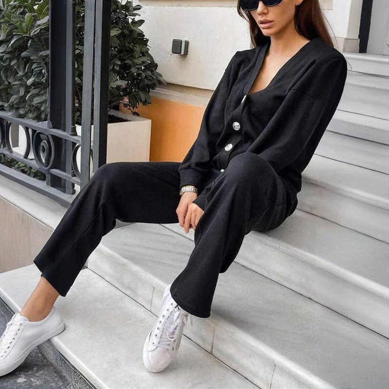 Woman in a black outfit with white sneakers sitting on steps.