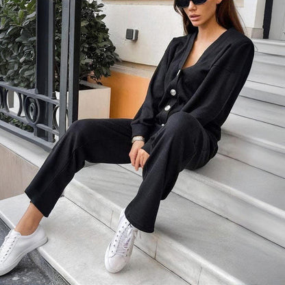 Woman in a black outfit with white sneakers sitting on steps.