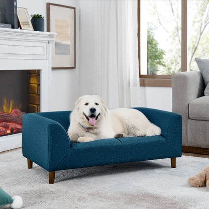 Dog lying on a blue pet bed in a cozy living room with a fireplace and sofa.