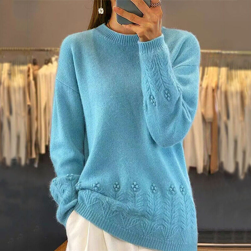 Person wearing a blue knitted sweater with floral patterns in a clothing store.