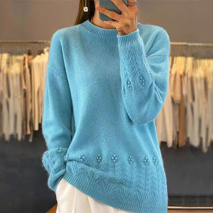 Person wearing a blue knitted sweater with floral patterns in a clothing store.