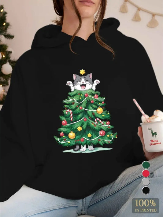 Person wearing a black hoodie with a Christmas tree and cat design, holding a drink.