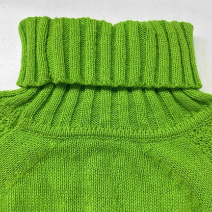 Close-up of a green knitted sweater with a ribbed collar on a light gray background