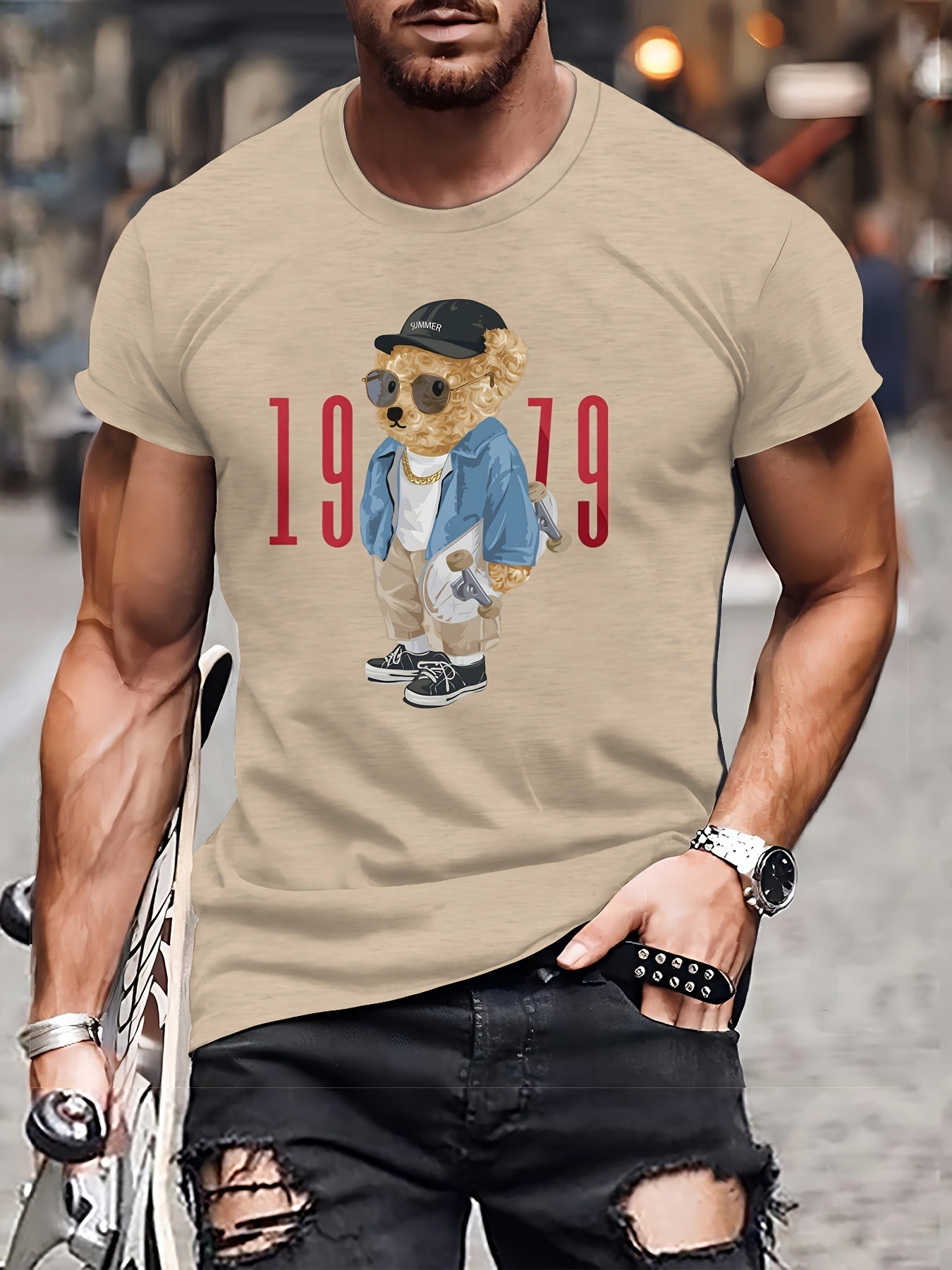 Man wearing a beige t-shirt with a graphic of a bear in a suit and sunglasses, with the text '1979'.