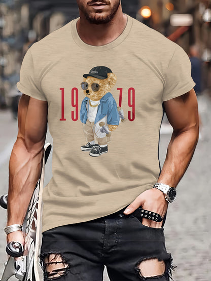 Man wearing a beige t-shirt with a graphic of a bear in a suit and sunglasses, with the text '1979'.