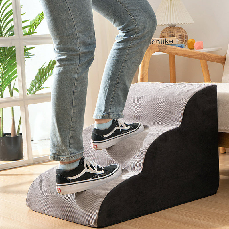 Person using a footstool in a living room setting